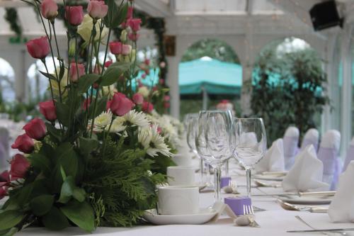 a table with wine glasses and a vase of flowers at B/W Plus Buxton Lee Wood Hotel in Buxton