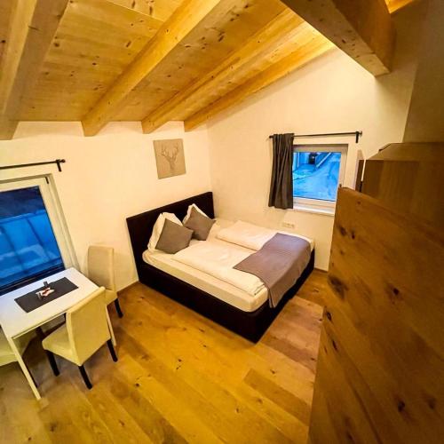 a bedroom with a bed and a table and a desk at EMMA's Studio in Gerlos