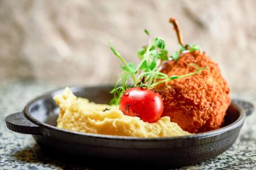 a bowl of food with a tomato on top at Radisson Blu Resort Bukovel in Bukovel