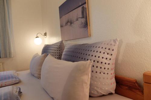 um quarto com uma cama com almofadas brancas em Ferienwohnung Hofblick em Pommerby