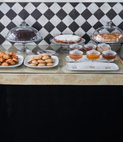 uma mesa coberta com pratos de comida e sobremesas em Hotel Solar Dos Mascarenhas em Vila Viçosa