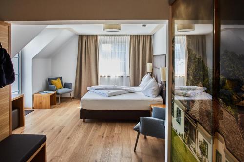 a small hotel room with a bed and a window at Hotel Donauhof in Emmersdorf an der Donau