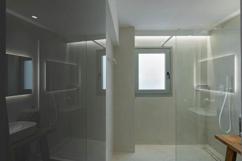 a bathroom with a glass shower and a sink at Boho Sapiens Blue Perlite in Adamas