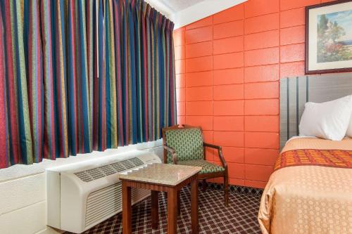 a room with two beds and a table and a chair at Rodeway Inn in Nashville