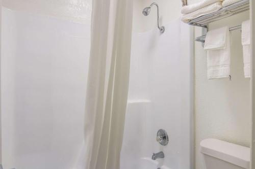 a white bathroom with a shower and a toilet at Rodeway Inn in Nashville