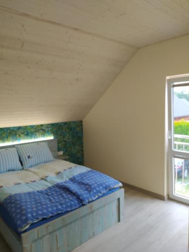 a bedroom with a bed and a window at Milagro Baltico in Dębki