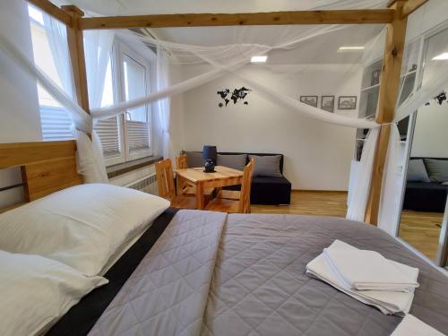 a bedroom with a large bed and a table at Apartament pod Zamkiem in Nowy Sącz