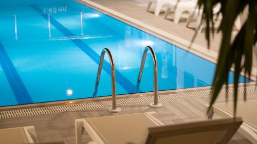 a swimming pool with rails next to a table and chairs at OPERA Boutique Hotel in Antalya