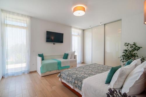 a bedroom with a bed and a couch and a tv at Villa R&B in Sutivan