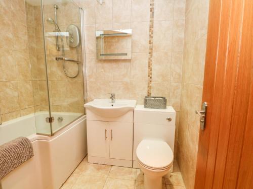 a bathroom with a toilet and a sink and a shower at The Mistal in Keighley