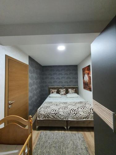 a bedroom with a large bed with a zebra print sheets at Avio Lux Apartmani in Novi Pazar