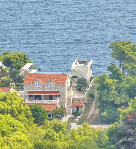 a house on a hill next to the water at Villa Mirosa in Saplunara