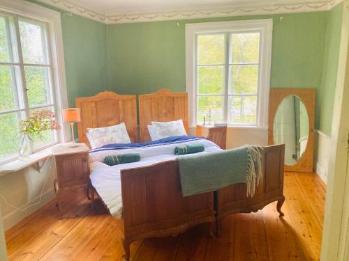 1 dormitorio con 1 cama grande en una habitación con ventanas en 5 bed country home only 2 hrs north of Stockholm, en Garpenberg