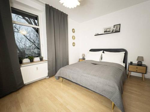 ein Schlafzimmer mit einem Bett und einem großen Fenster in der Unterkunft Purer Luxus mit 2 Schlafzimmern, Balkon und Privat-Parkplatz in Leipzig
