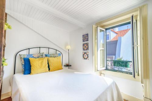 Habitación blanca con cama y ventana en BeGuest Cozy Flat Sant ´Ana, en Lisboa