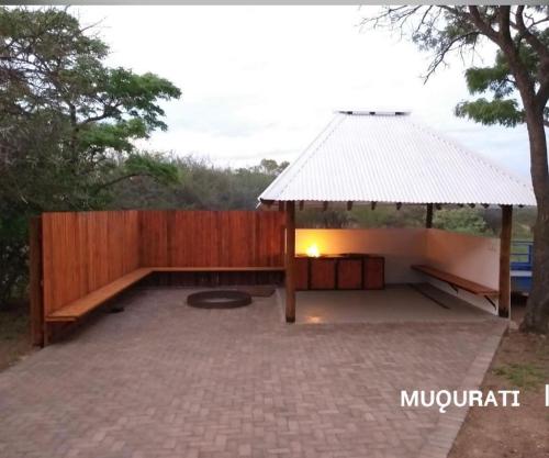 a backyard with a gazebo and a wooden fence at Muqurati Lodge - Dinokeng Game Reserve in Klipdrift