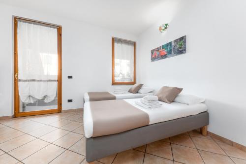 1 Schlafzimmer mit 2 Betten und einem Fenster in der Unterkunft Casa da Suite Rho in Rho