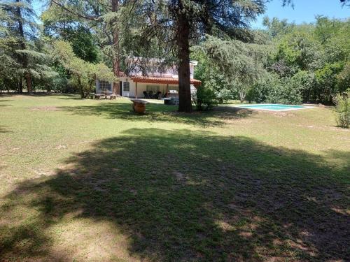 una casa con un árbol delante de un patio en Casa de Campo entera en 