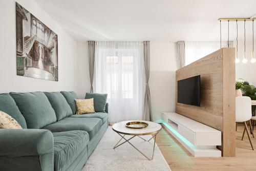 a living room with a blue couch and a tv at VISIMO Apartments Chur in Chur
