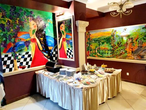 a table in a room with paintings on the walls at Rezydencja Izabella in Wisła
