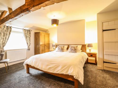 ein Schlafzimmer mit einem Bett und einem Fenster in der Unterkunft Bodaioch Cottage in Caersws