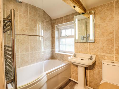 ein Badezimmer mit Badewanne, Waschbecken und Toilette in der Unterkunft Bodaioch Cottage in Caersws