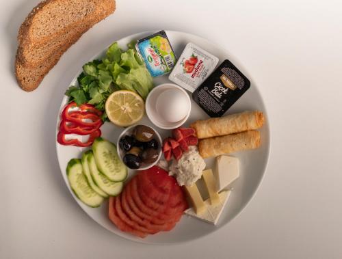 un plato de comida con queso, verduras y pan en OPERA SUITES Apart Hotel, en Antalya