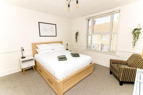 un dormitorio con una cama y una silla en Beautiful City-Centre Townhouse with Hot Tub, en Norwich