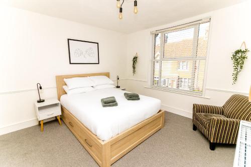 a bedroom with a bed and a chair at Beautiful City-Centre Townhouse with Hot Tub in Norwich