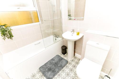 Un baño blanco con lavabo, bañera e inodoro. en Beautiful City-Centre Townhouse with Hot Tub, en Norwich