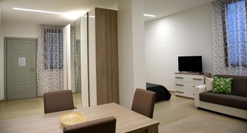 sala de estar con mesa, sofá y TV en Dea Igea Apartment, en Bellaria-Igea Marina