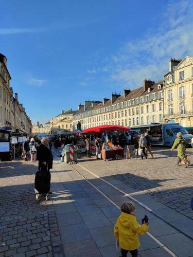 un enfant qui prend une photo d'un marché dans une ville dans l'établissement L'expérience d'Elie by Icone Collection, à Caen