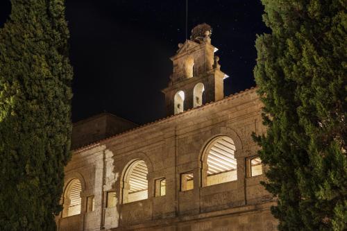 a building with a clock tower at night at Abadia Retuerta LeDomaine in Sardoncillo