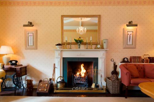 a living room with a fireplace and a mirror at Hazel Bank Country House Borrowdale Valley in Rosthwaite