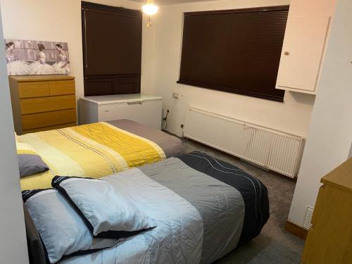 a bedroom with two beds and a window at Mansion 8 bedrooms in Private Gated Ave Huge garden Hot tub FREE SAUNA up to 23 in Luton