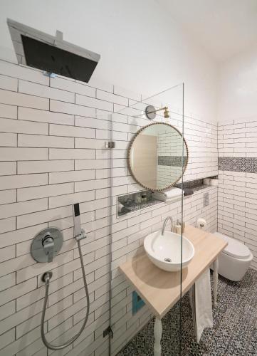 a bathroom with a sink and a mirror and a toilet at Baross Boutique Apartman in Győr