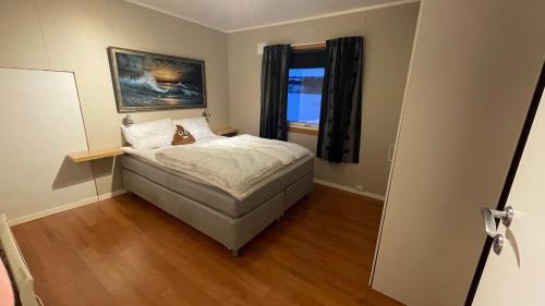 ein kleines Schlafzimmer mit einem Bett und einem Fenster in der Unterkunft Koselig hus i sentrum av Olderfjord in Russenes