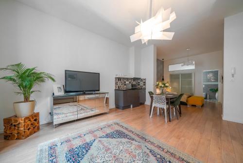 a living room with a television and a table with chairs at Baross Boutique Apartman in Győr