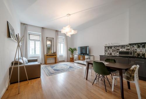 a living room with a table and a dining room at Baross Boutique Apartman in Győr
