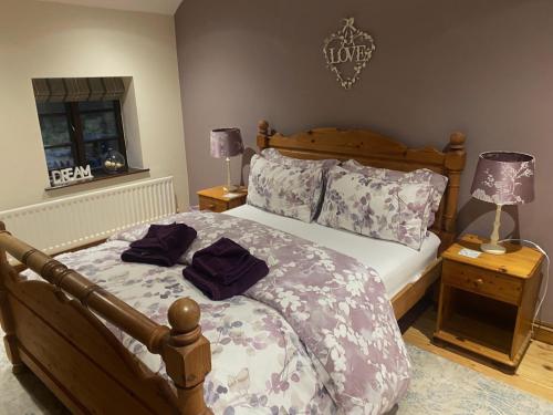 a bedroom with a large bed with a wooden frame at Waterside Cottages in Waterhouses