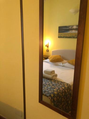 a bedroom with a mirror and a bed at Notti Etrusche a Sovana in Sovana