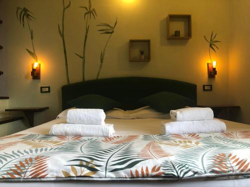 a bed with two pillows and a night stand at Notti Etrusche a Sovana in Sovana
