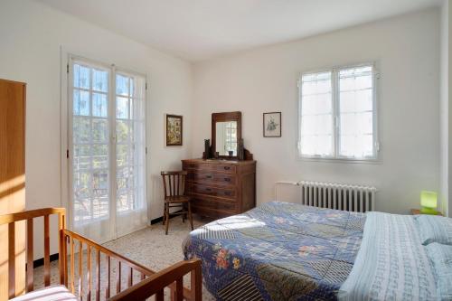 Schlafzimmer mit einem Bett, einer Kommode und Fenstern in der Unterkunft Dacia tra Cielo e Mare in Villa Faraldi