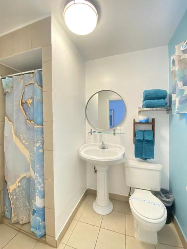 een badkamer met een wastafel, een toilet en een spiegel bij Bluebird Day Inn & Suites in South Lake Tahoe