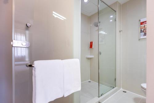 a white bathroom with a shower and a towel at Red Planet Hat Yai SHA extra plus in Hat Yai
