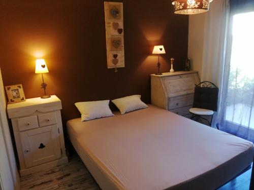 1 dormitorio con 1 cama blanca grande y 2 lámparas en Lac d'Annecy T2 grand jardin en Doussard