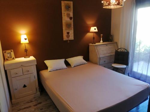 een slaapkamer met een groot wit bed en 2 lampen bij Lac d'Annecy T2 grand jardin in Doussard