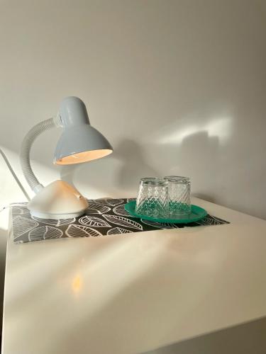 a table with a lamp and two glasses on it at Yaremche House in Yaremche