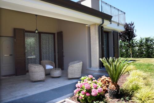 a patio with wicker chairs and flowers on a house at Villa al Mare in Bellaria-Igea Marina