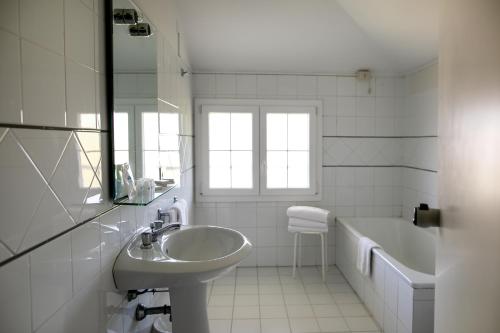 a white bathroom with a sink and a tub at Casa F.A.C.I in Marina di Massa